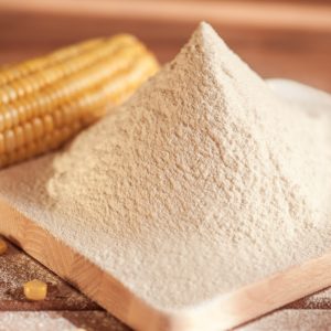 corn flour and corn on the cob on a wooden table